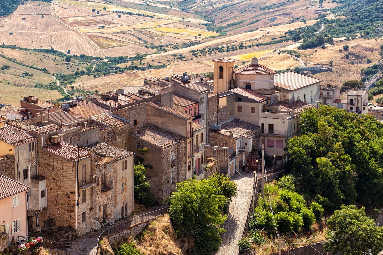 Sentiero panoramico che collega borghi storici, circondato da natura e antichi edifici.