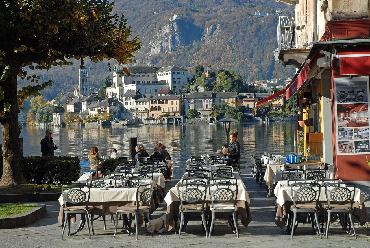 Vista di un borgo storico lombardo con piatti tipici serviti in un ristorante all'aperto.