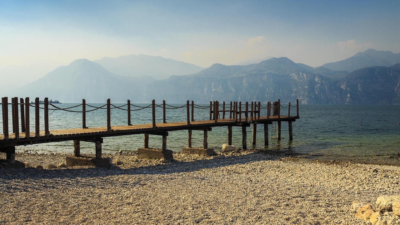Spiaggia tranquilla del Lago d'Iseo con acque serene e natura circostante per un relax totale.