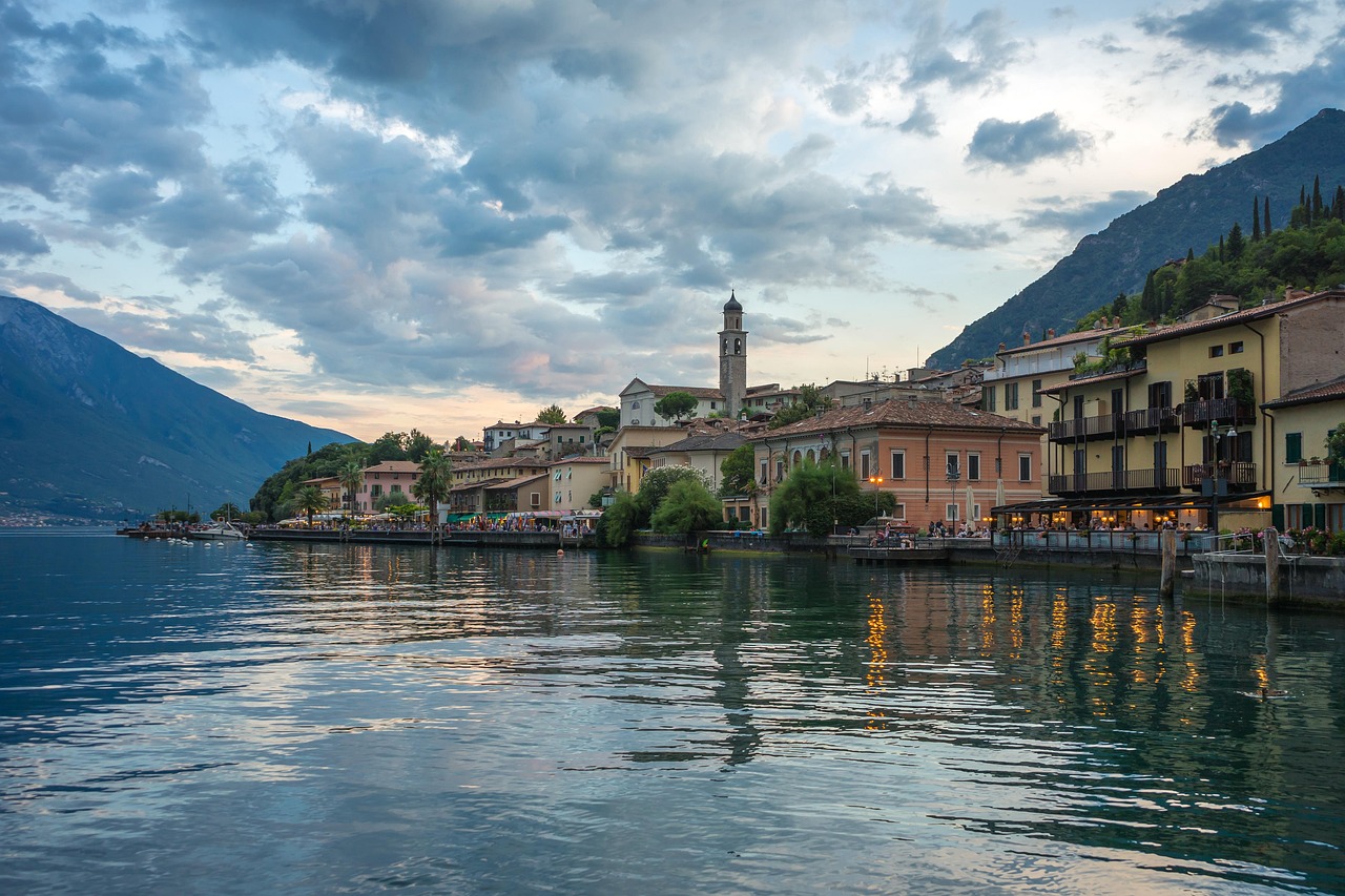 Panorama suggestivo dei borghi sulla sponda orientale del Lago d'Iseo, con lago e montagne sullo sfondo.