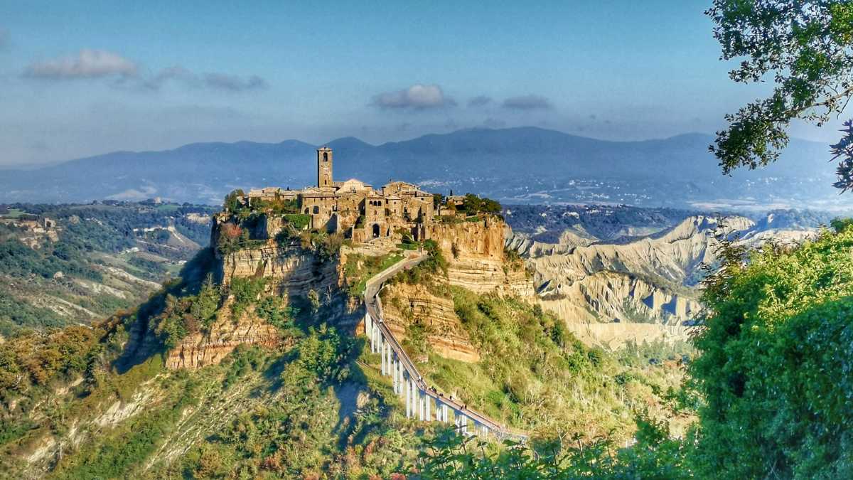 Vista panoramica di un borgo fantasma in Italia, con edifici abbandonati e natura circostante.