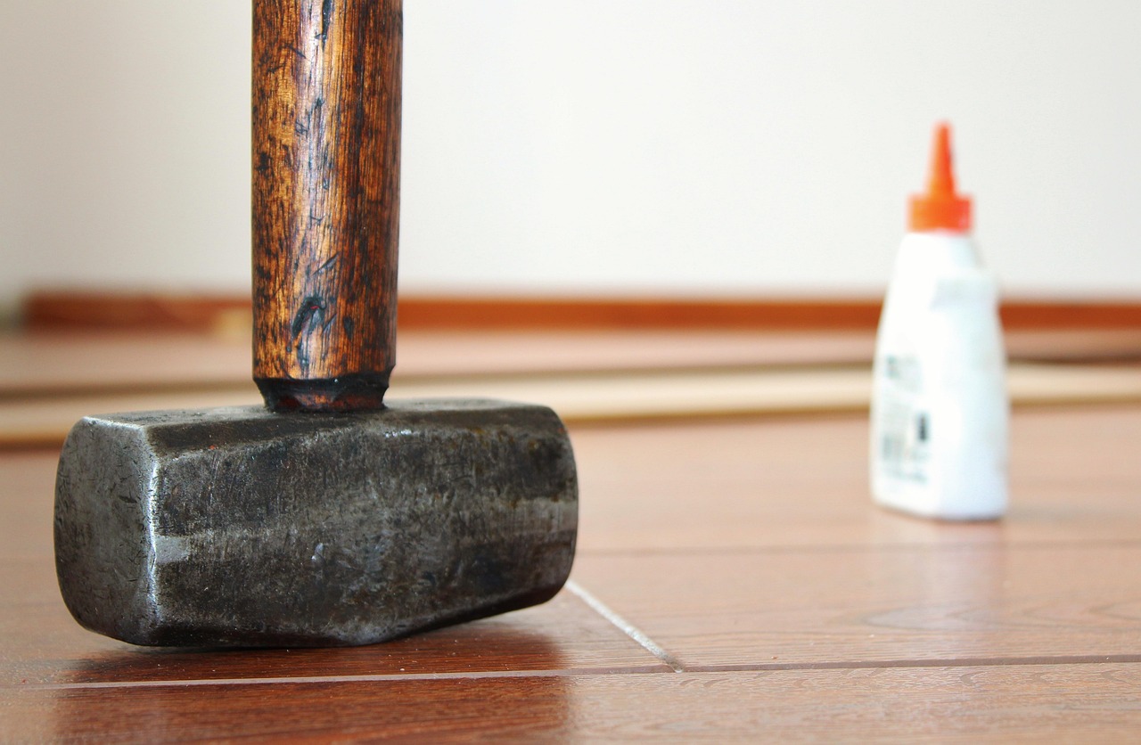 Pavimento in legno che scricchiola, attrezzi per la riparazione a disposizione.