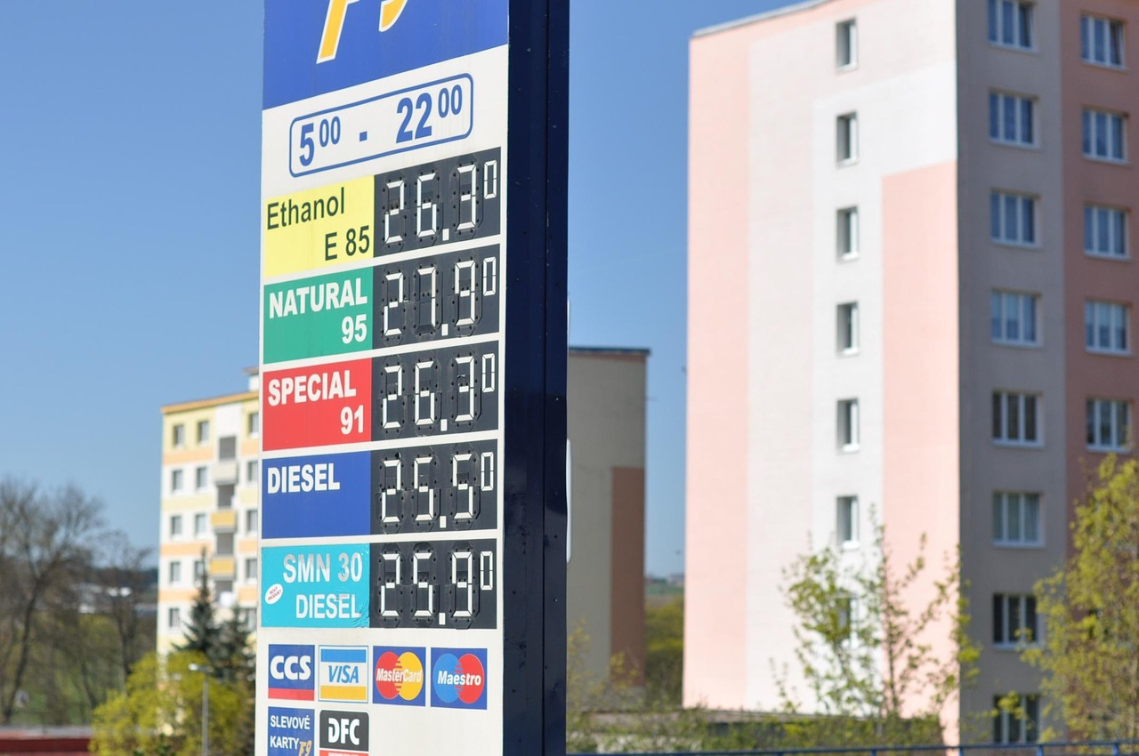 Benzina in una pompa di carburante con prezzi esposti, simbolo dell'inaspettato aumento dei costi.