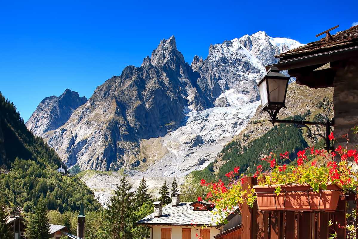 Panorama montano con alberi e cielo blu, ideale per vacanze economiche nel 2026.