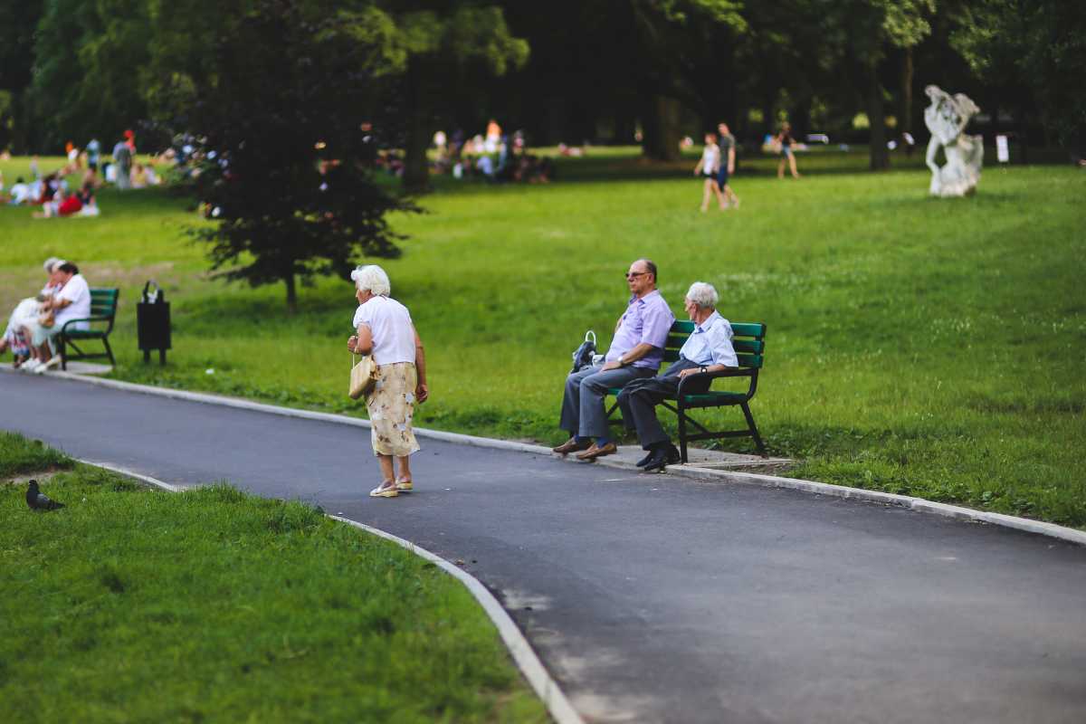 Uomo anziano sorride mentre legge notizie su agevolazione per over 70.