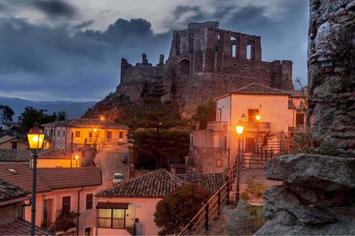 Borgo siciliano con castello arabo ben conservato, circondato da paesaggi suggestivi.