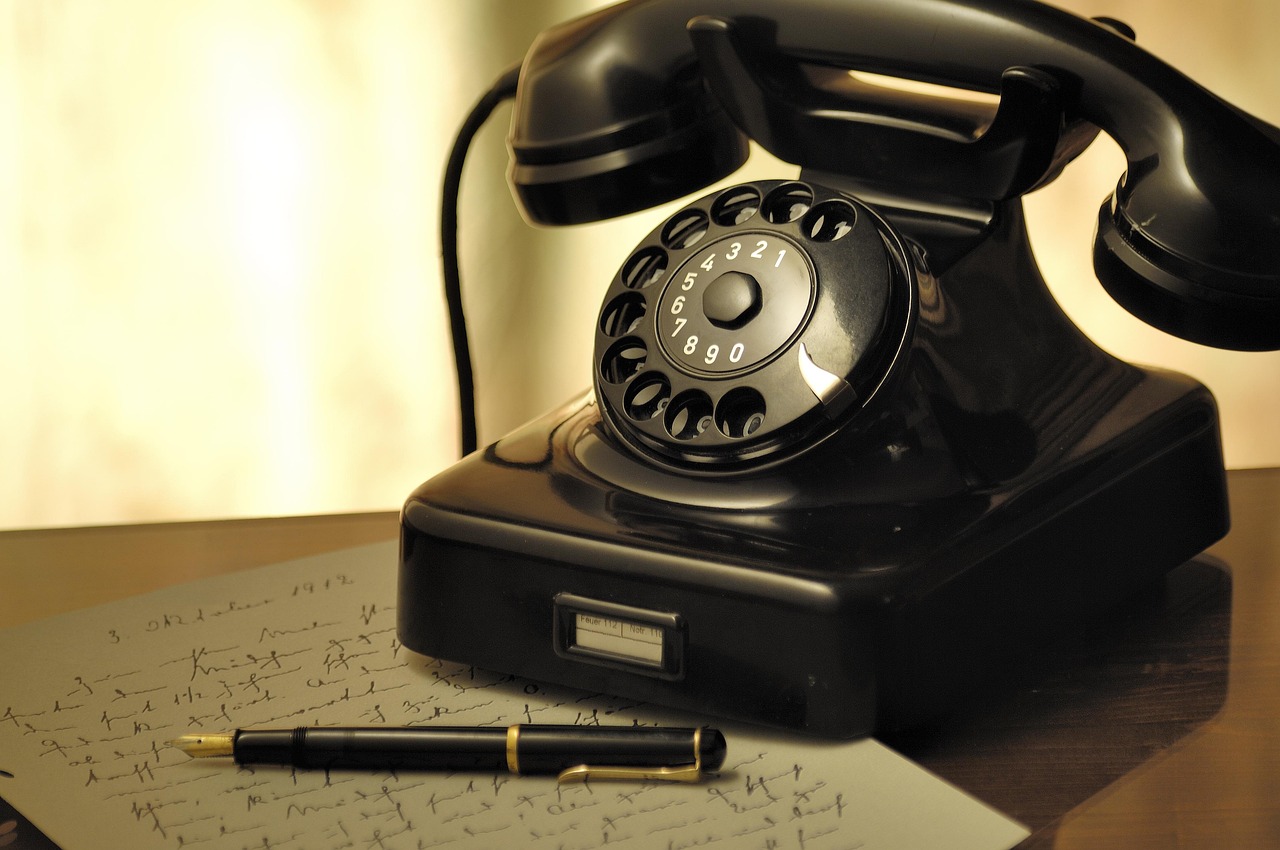 Telefono a disco vintage su sfondo legno, simbolo di nostalgia e design retrò.